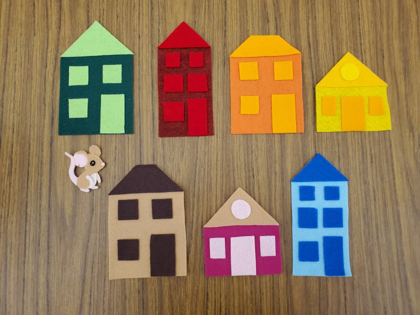 Picture of flannel pieces for the hide-and-seek game Little Mouse. Includes 7 houses of varying colors and sizes and one mouse small enough to hide behind any of them.