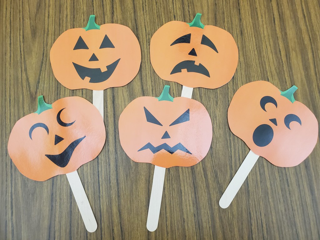 Laminated pumpkins mounted on craft sticks with faces depicting 5 feelings: happy, sad, mad, scared, and silly.