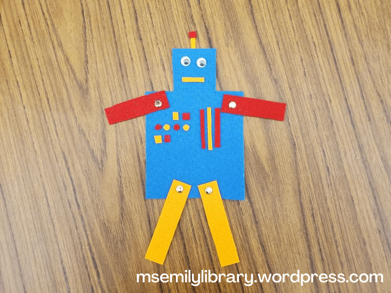 Felt robot craft in blue, red, and orange, with gold brads holding on the arms and legs