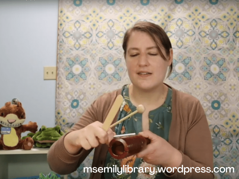 Screenshot of video, showing the rasp instrument and me holding three implements to make different sounds on it.