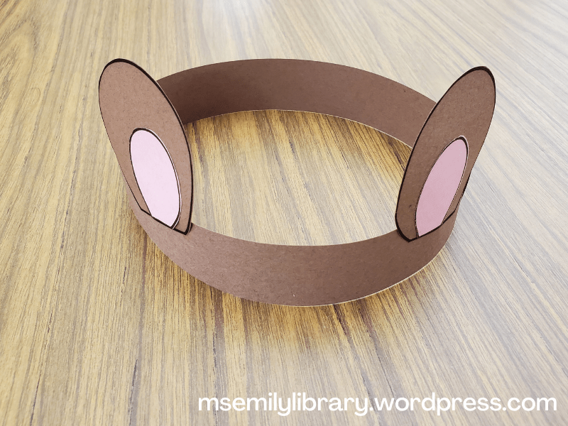 picture of bear ears headband - brown construction paper band with brown bear ears (and pink inner ear) glued on.