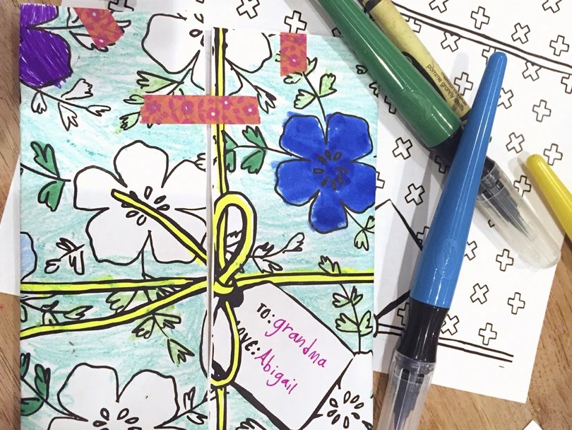 picture of printed grandparents day card, showing one colored in, some markers and crayons, and one blank.