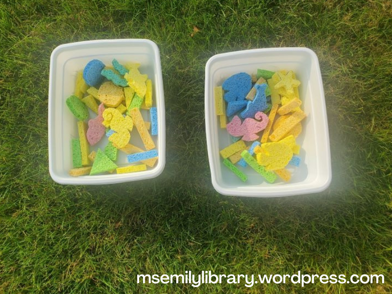 Picture of two bins with multicolored sponges in them.  Shapes include seahorses, fish, sea stars, clamshells, dolphins, triangles, sticks, and circles.