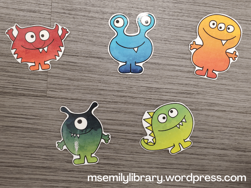 five printed and laminated monsters in variegated colors - red, blue, orange, dark green, and light green.