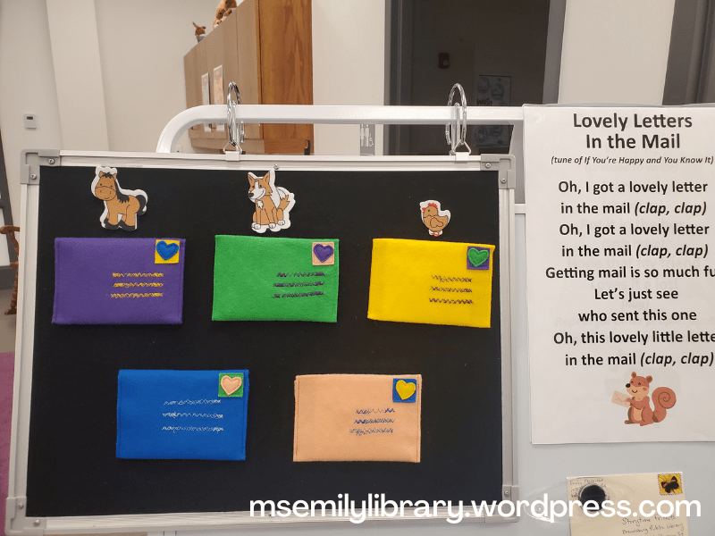 Easel with feltboard, showing 5 envelopes, three of which have the corresponding animal felt next to them. The lyrics to "Lovely Letters in the Mail" is to the side.