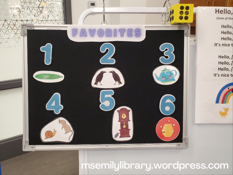 Flannelboard marked "Favorites" at the top, then numbered 1-6. Icons are: 1 peapod 2 blackbirds facing each other, 3 teapot with smiley face 4 snail and mouse 5 grandfather clock with mouse 6 beehive surrounded by bees