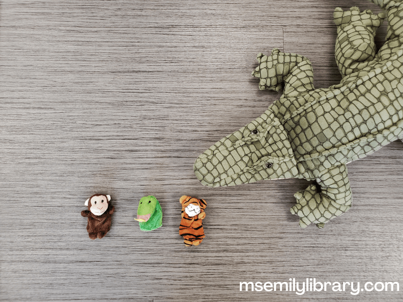 Three small finger puppets (monkey, snake, and tiger) and a much larger alligator puppet.