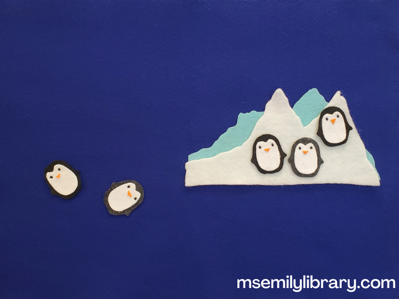 five penguins flannel, showing a two layer ice bank of light blue behind white felt. Three felt penguins are on the ice bank, and two are "swimming" beside it.