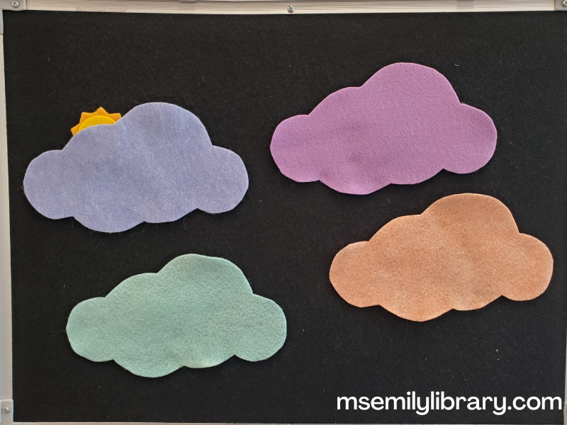 find the sun flannel, showing four big cloud shapes - blue, purple, mint green, and peach colored, with a yellow sun peeking from behind the blue one.