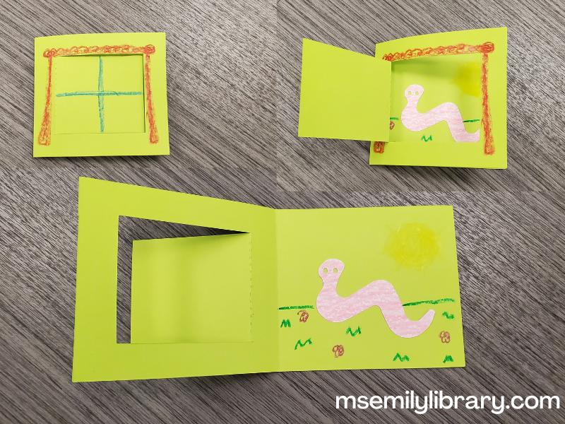 collage of three pictures of the craft - one showing the folded sheet closed, with a window drawn on. The second shows a flap opened (window pane) showing a worm. Third showing the folded sheet open, showing the full landscape of the worm on grass.