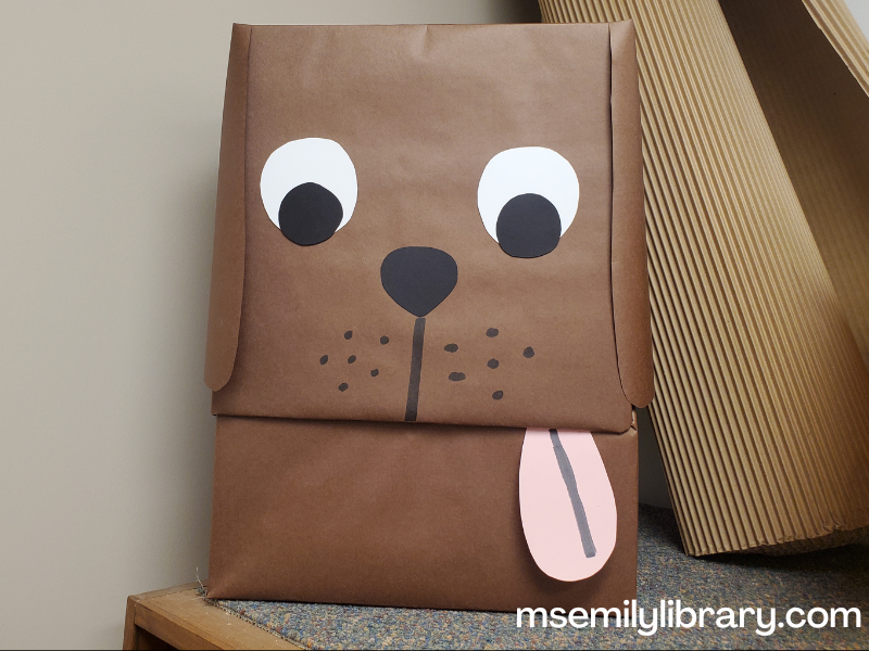 bark george puppet, made from a box covered in brown paper with eyes, muzzle, ears, and tongue added. The mouth is where the box opens on a hinge.
