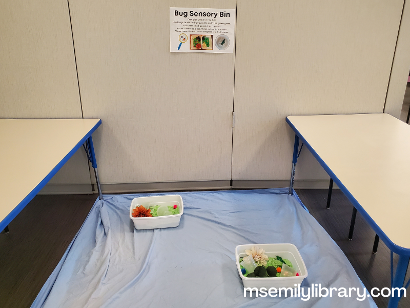 bug sensory bin station, showing two bins on a fitted sheet held down by two tables.