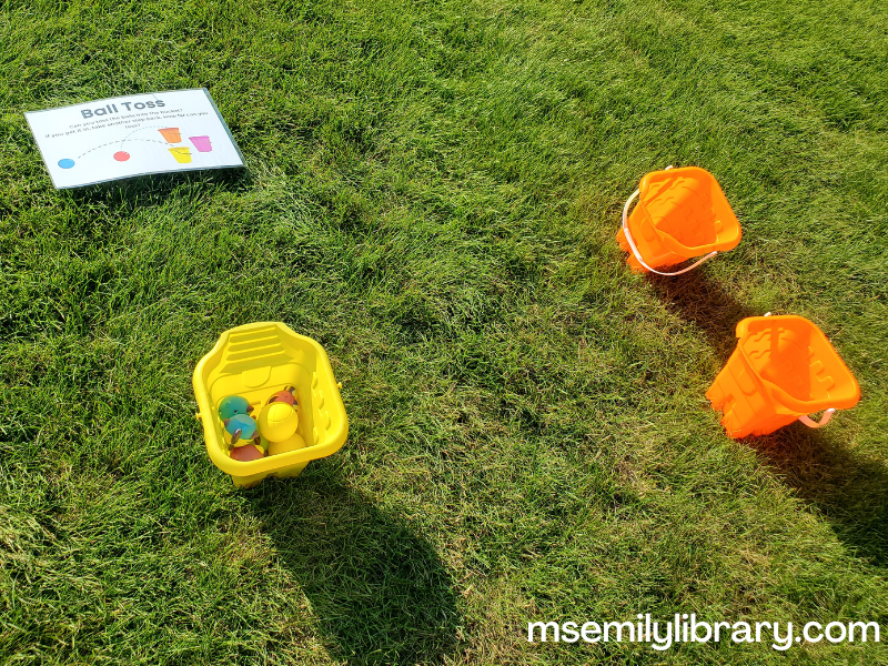 three sand buckets - two empty and one filled with soft balls and round fish squirter toys