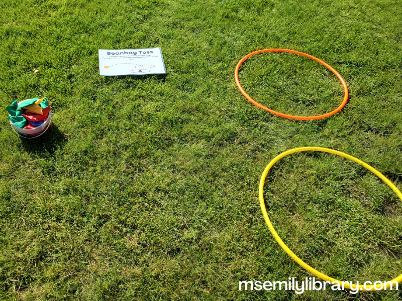 two hula hoops opposite a bucket of bean bags