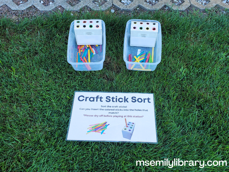 colored craft sticks with small boxes that have holes with coordinating colored rings around them