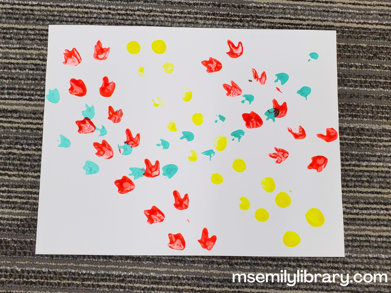 craft - white paper with different colored dinosaur prints (from plastic dinos) stamped on