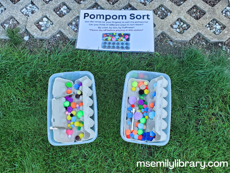 egg cartons filled with various colored/sized pom poms, with small metal tongs