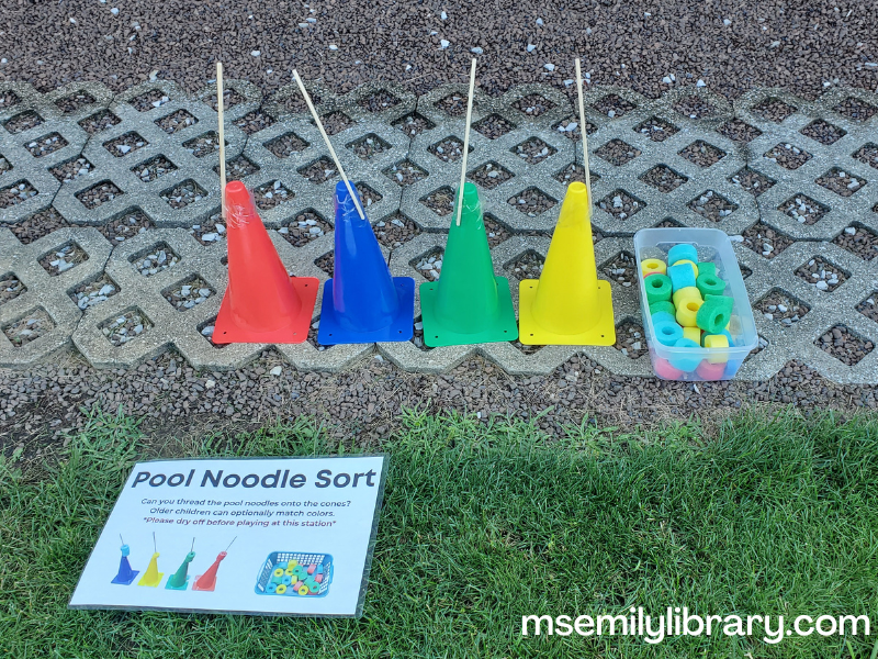 small athletic cones with wooden dowel rods taped to the top. Each is a different color, and coordinating colored pool noodle slices are in a basket beside