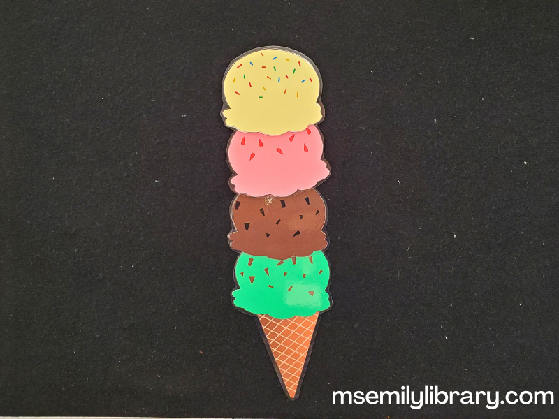 ice cream incident flannel, with printed and laminated pictures of a waffle cone topped with 4 scoops, mint green, brown chocolate, pink strawberry, and yellow vanilla. each scoop has sprinkles on.